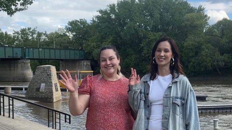 Two women waving to the camera.